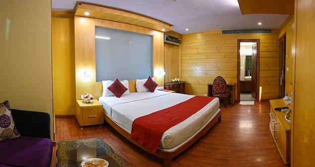 a double bed with sofa at emarald hotels resorts in new delhi hotel_Image