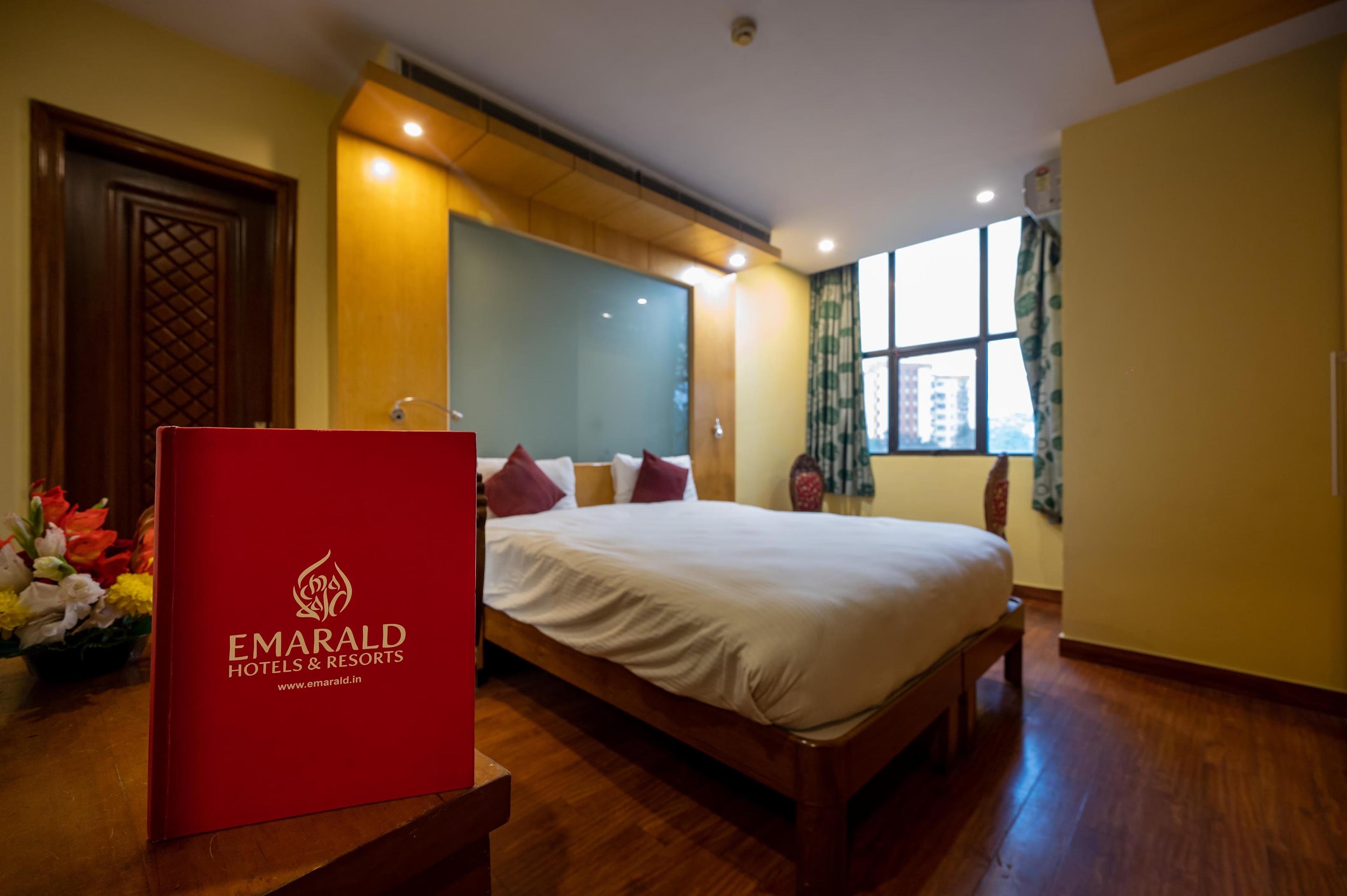 a double bed with sofa at emarald hotels resorts in new delhi hotel_Image