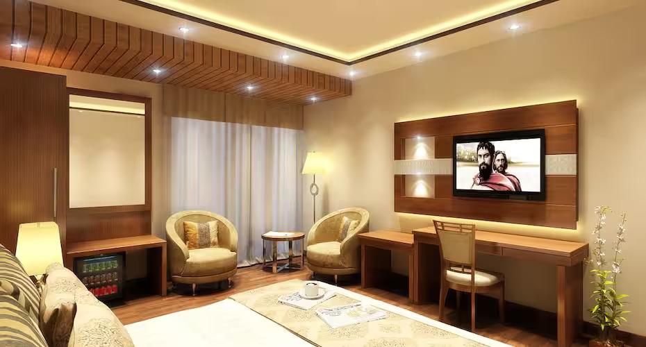 bed room with t.v with sofa at grand ffour new delhi hotel_Image