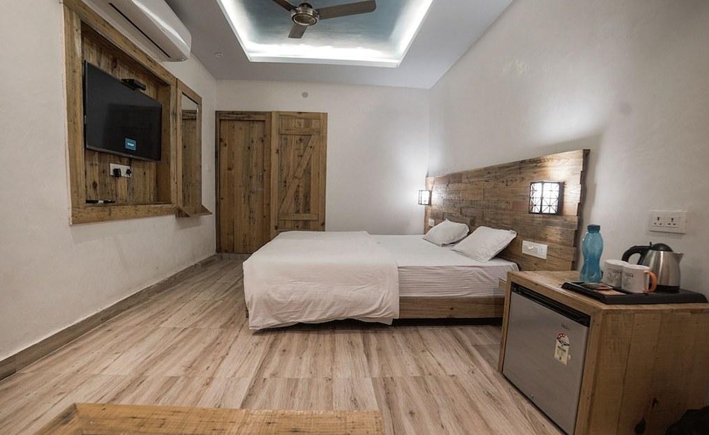 a bed room with t.v at hill top swiss cottage in rishikesh hotel_Image