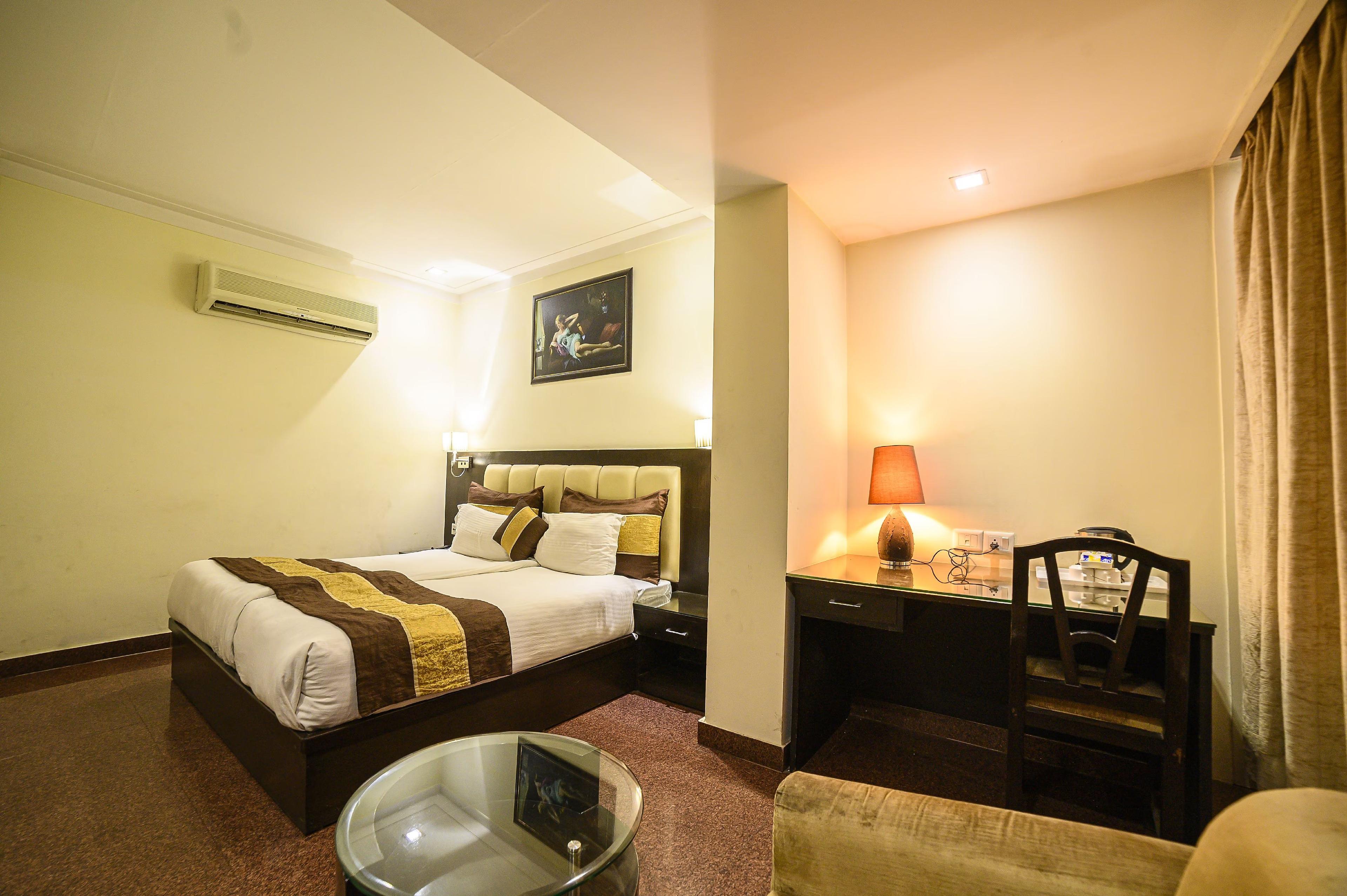 a bed room with t.v at hotel blue sapphire in agra hotel_Image
