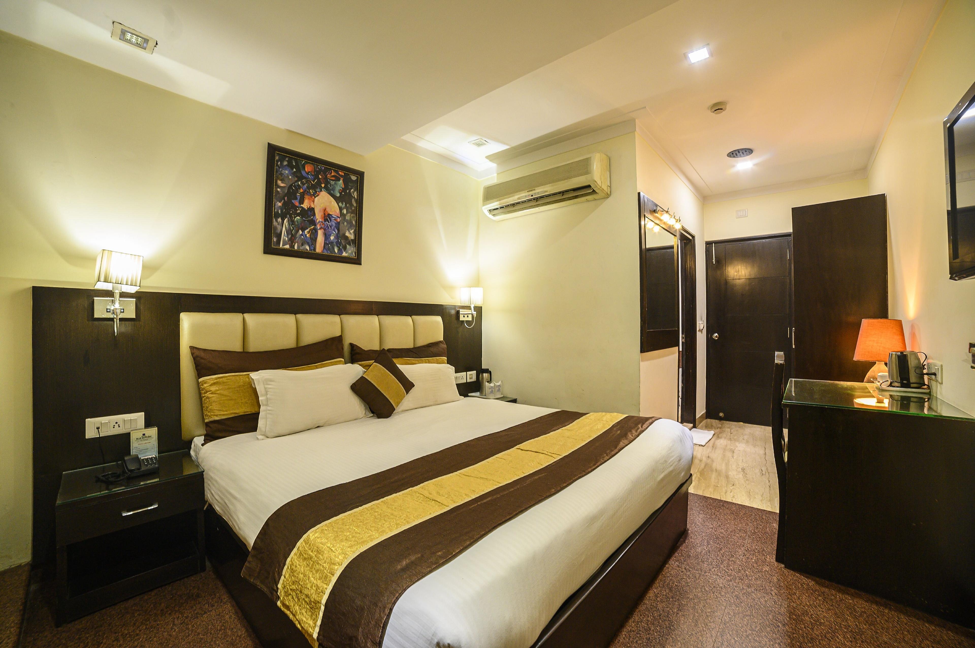 a bed room with t.v at hotel blue sapphire in agra hotel_Image