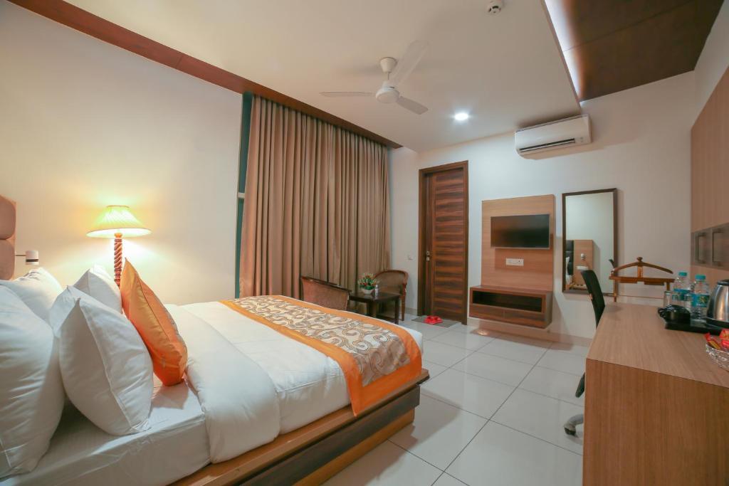 a double bed room with seating area at hotel grand regency new delhi airport in new delhi hotel_Image