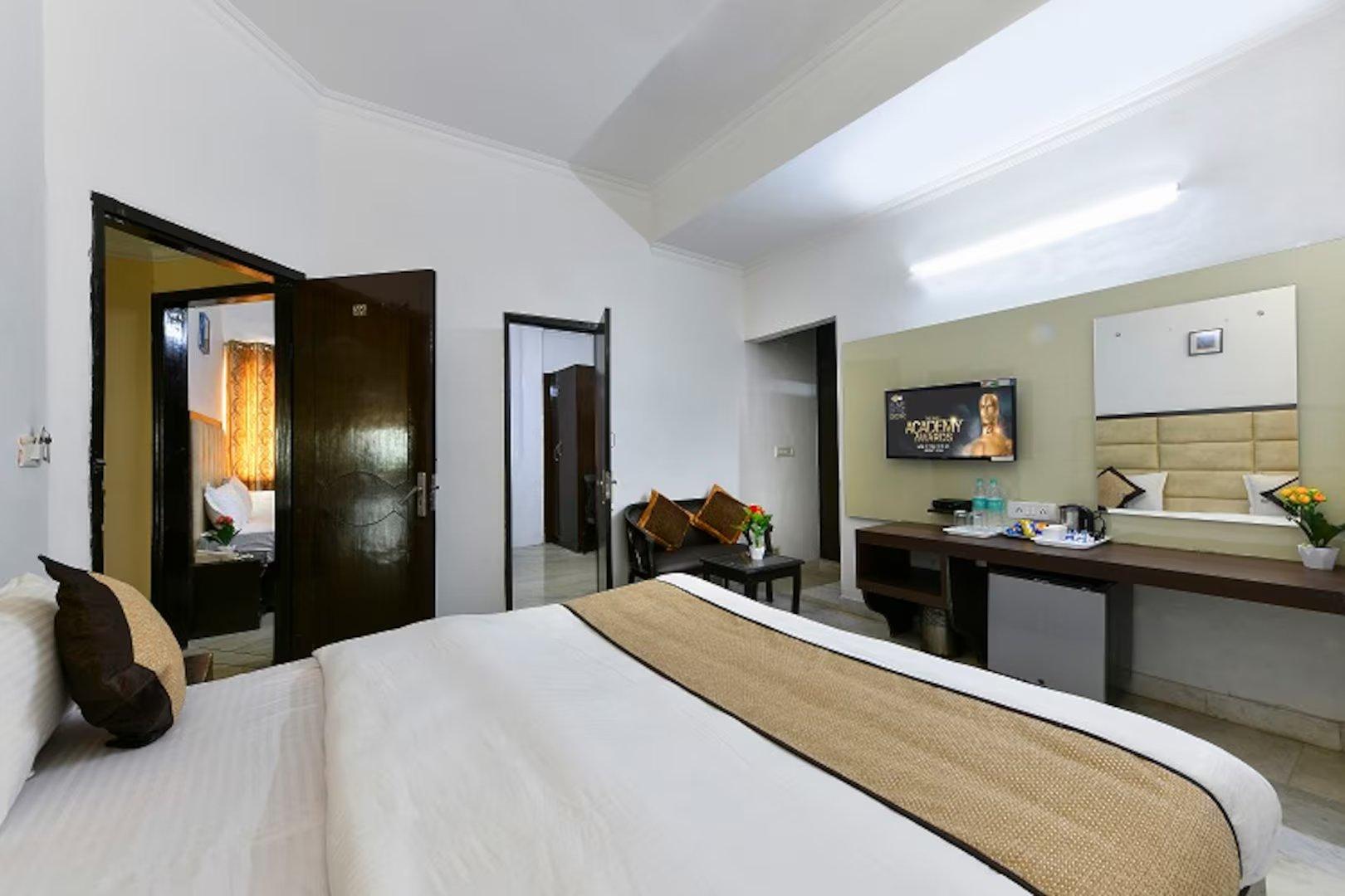 a bedroom with a large bed and a tv at hotel the first by goyal hoteliers in Aagra hotel_Image