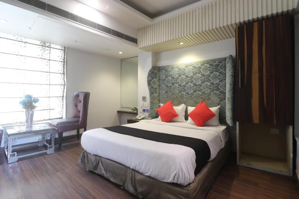a bedroom with a large bed and a table at hotel uppal international in new delhi hotel_Image