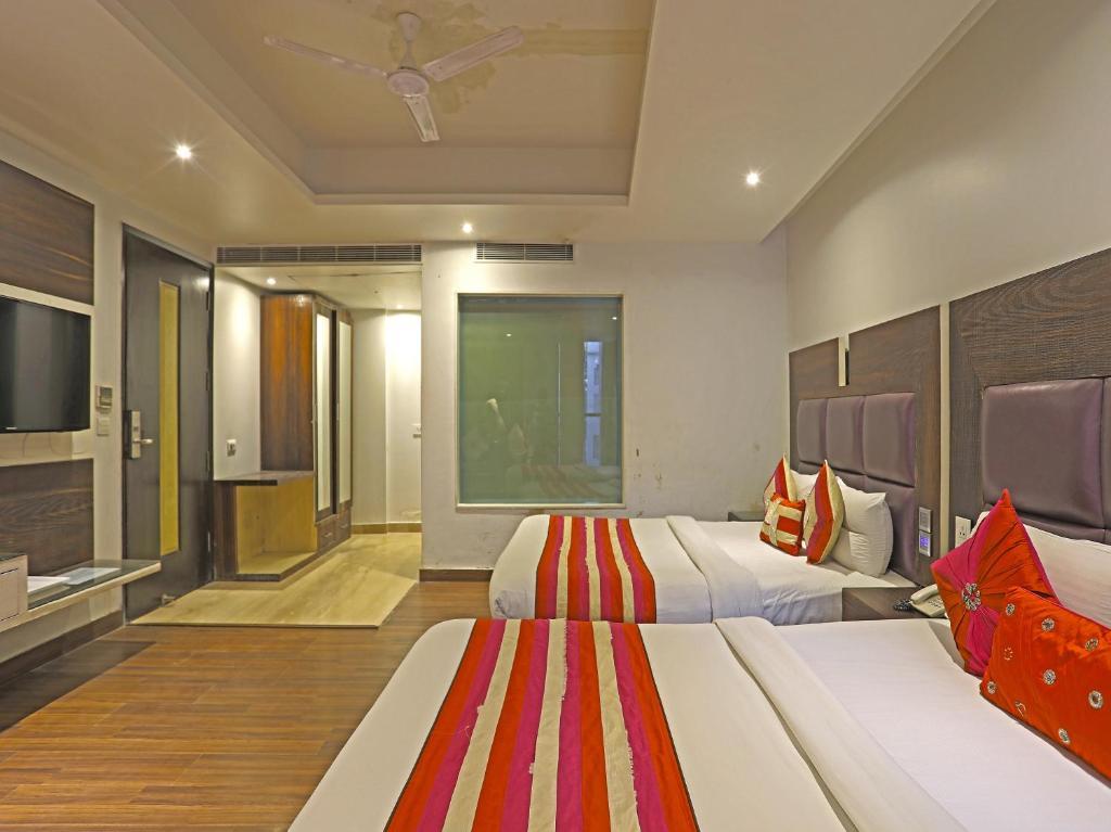 a bedroom with two single bed and a table at hotel uppal international in new delhi hotel_Image