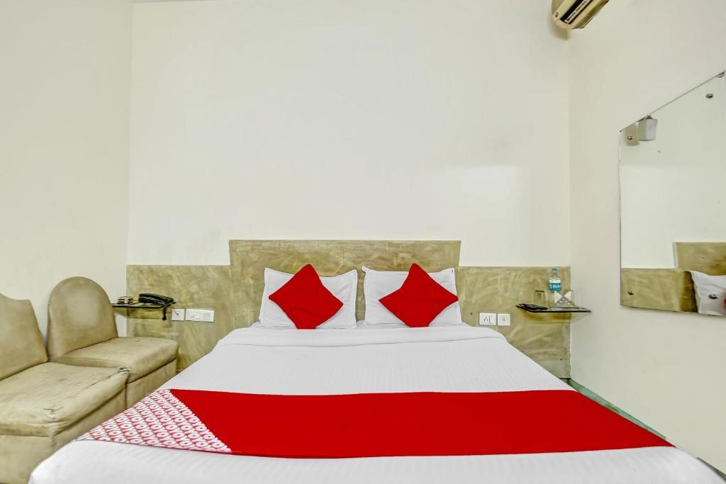 a bedroom with a large bed and red pillow at new crown continental in near sarai rohilla railway station hotel_Image