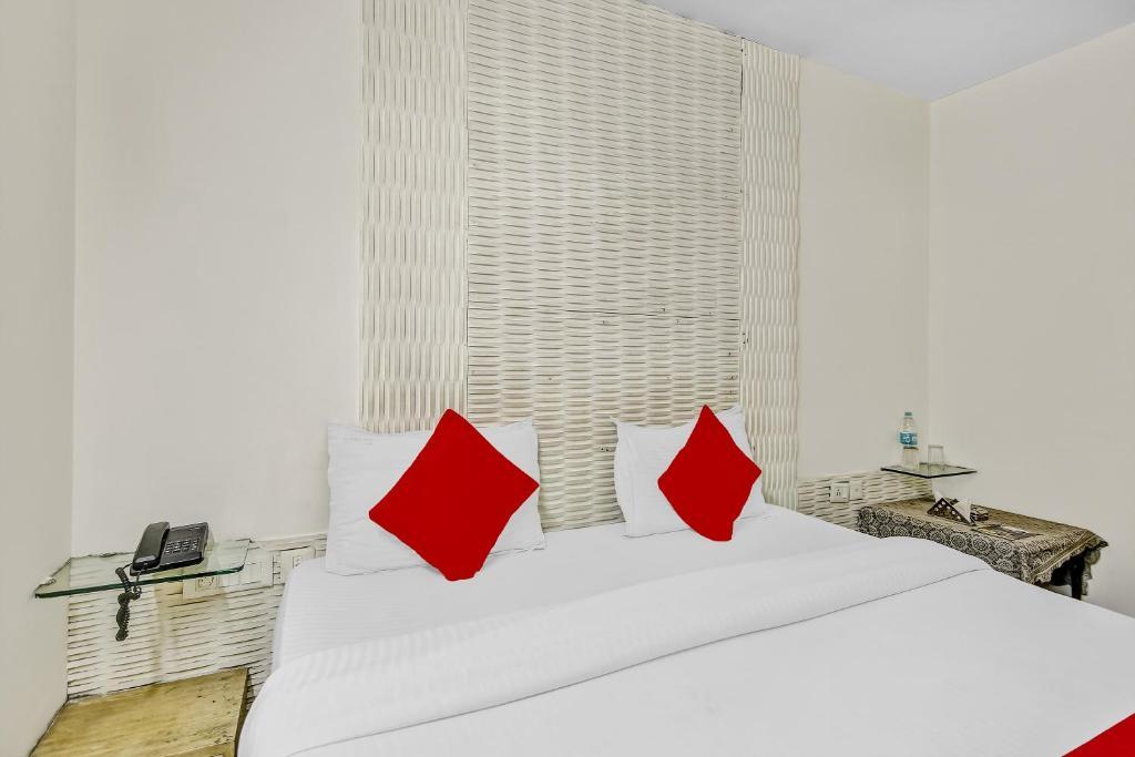 a bedroom with a large bed and red pillow at new crown continental in near sarai rohilla railway station hotel_Image