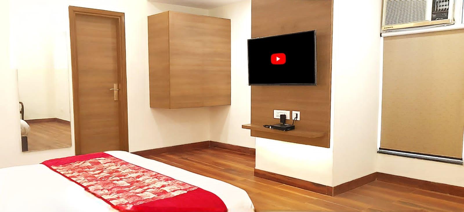 a bedroom with a tv at satyam hotel in new delhi hotel_Image