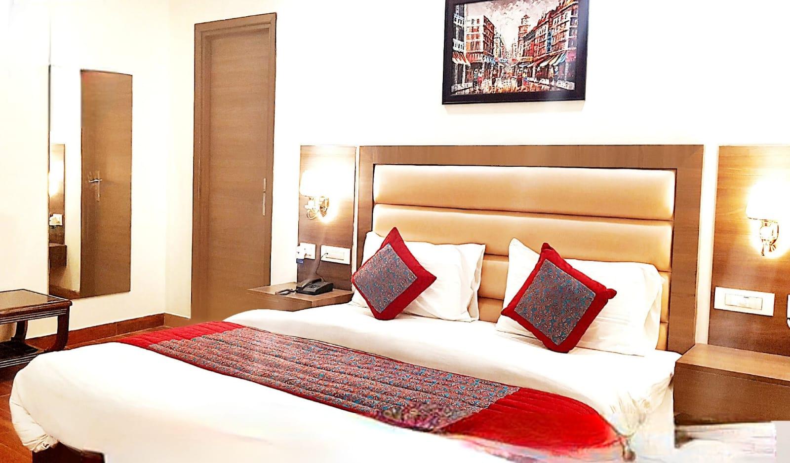 a bedroom with pics on wall at satyam hotel in new delhi hotel_Image