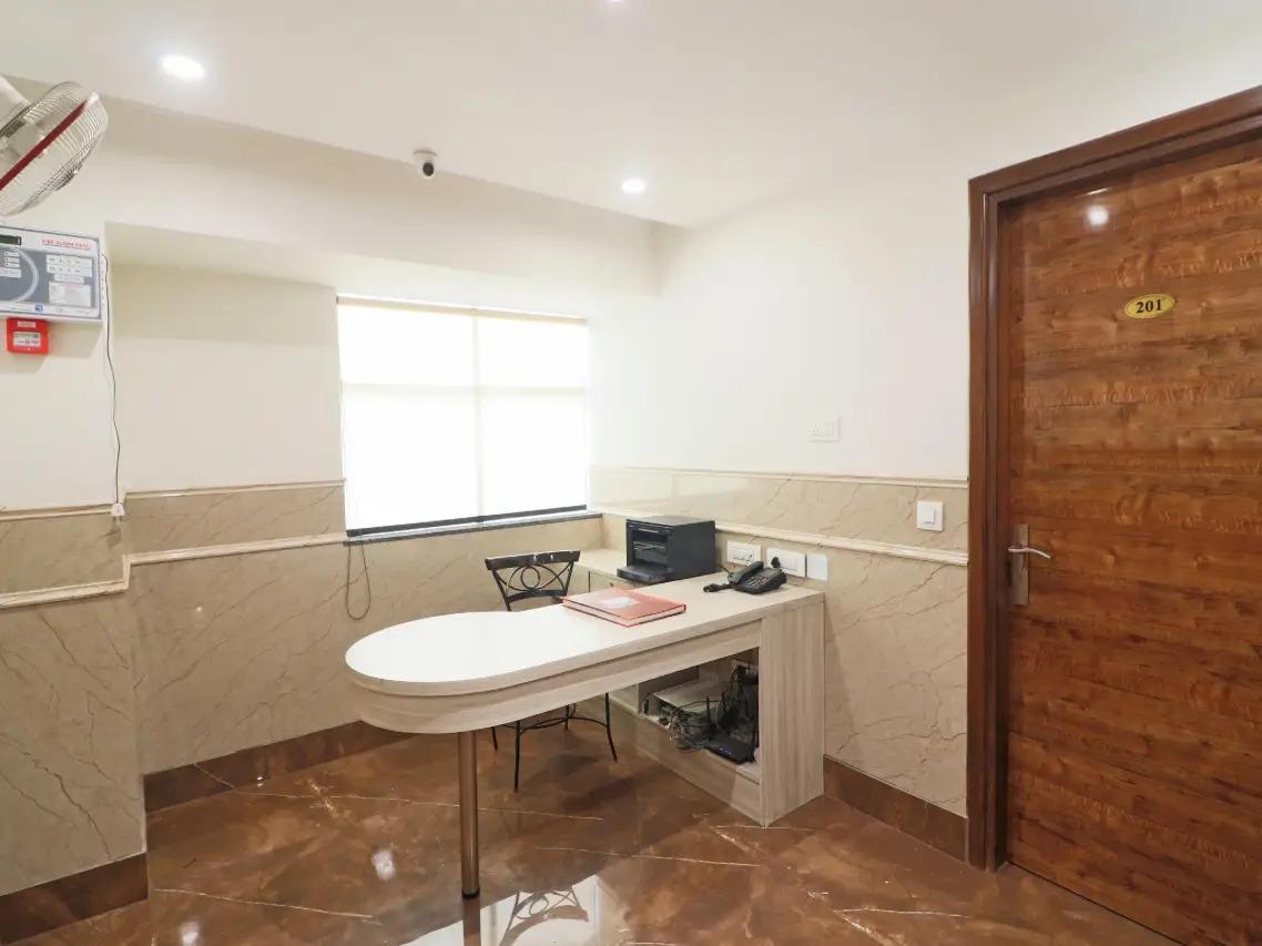 a bedroom with a table and chair at satyam hotel in new delhi hotel_Image