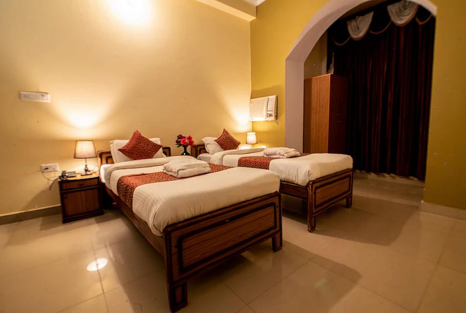 a bedroom with two single bed and white bedsit at sidhhi vinayak in ranthambore hotel_Image