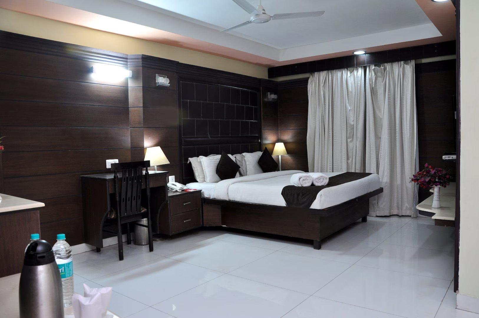 a bedroom with a large room and table at sun hotel in agra hotel_Image