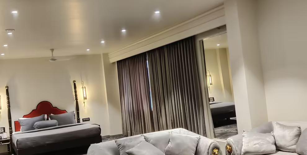 a bedroom with sofa set and living area at The Saga Hotel in New Delhi hotel_Image