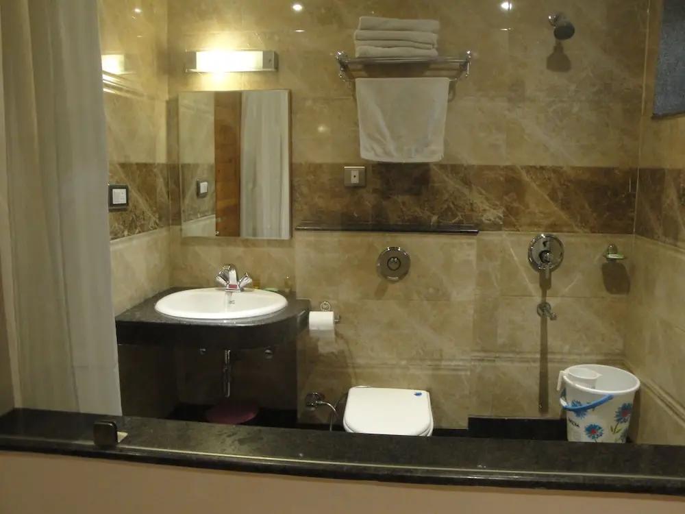 a bathroom with a toilet and a sink at The Urmi hotel in Haridwar hotel_Image