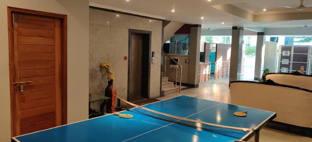 a reception area with stairs and play board at The Urmi hotel in Haridwar hotel_Image