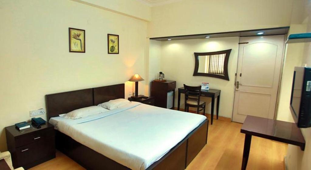 a bedroom with one chair and table at YMCA Tourist Hotel in New Delhi hotel_Image
