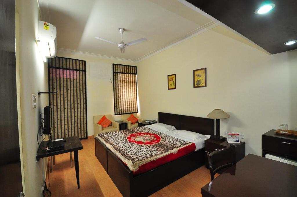 a bedroom with pillow tv, table and chair at YMCA Tourist Hotel in New Delhi hotel_Image