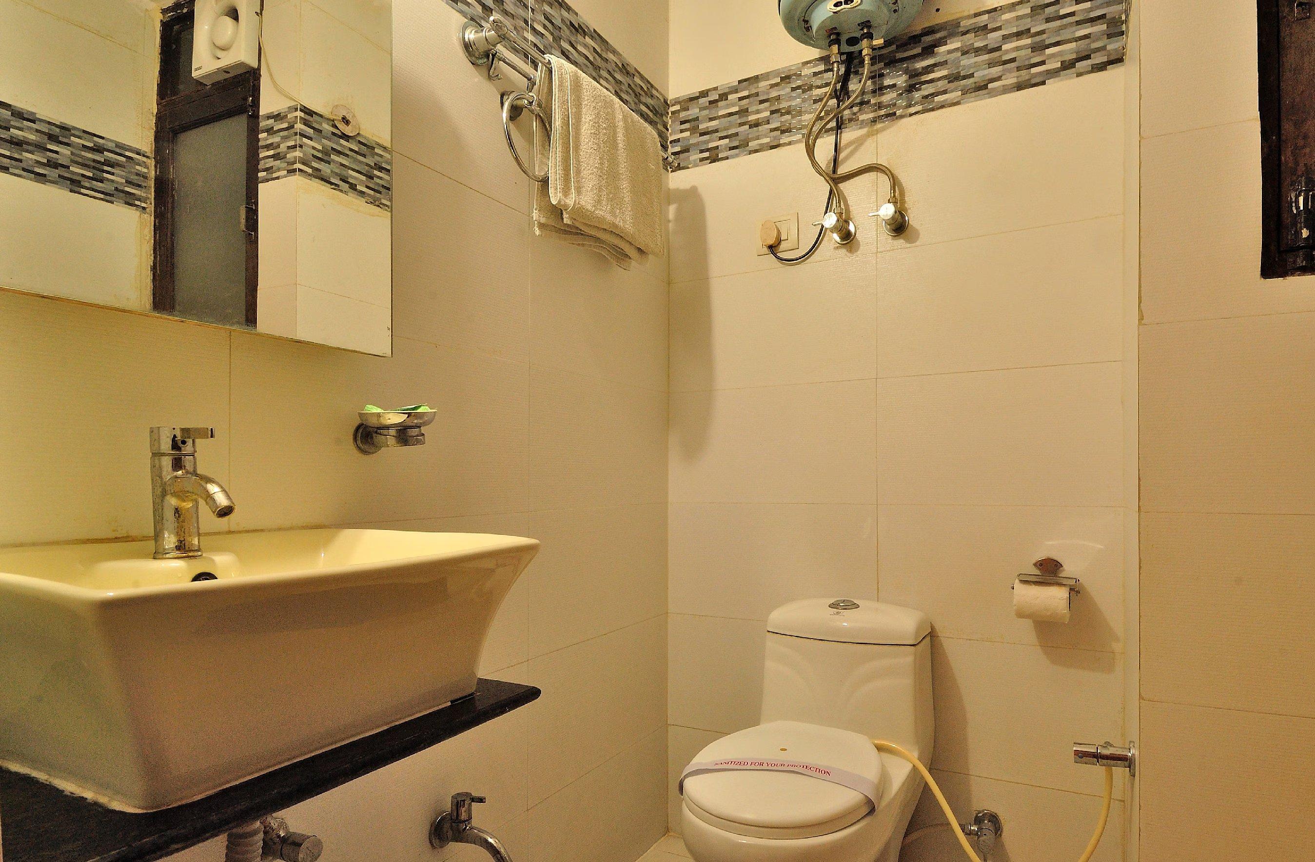 a bathroom with a toilet and a sink at travok resort and spa in mussoorie hotel_Image