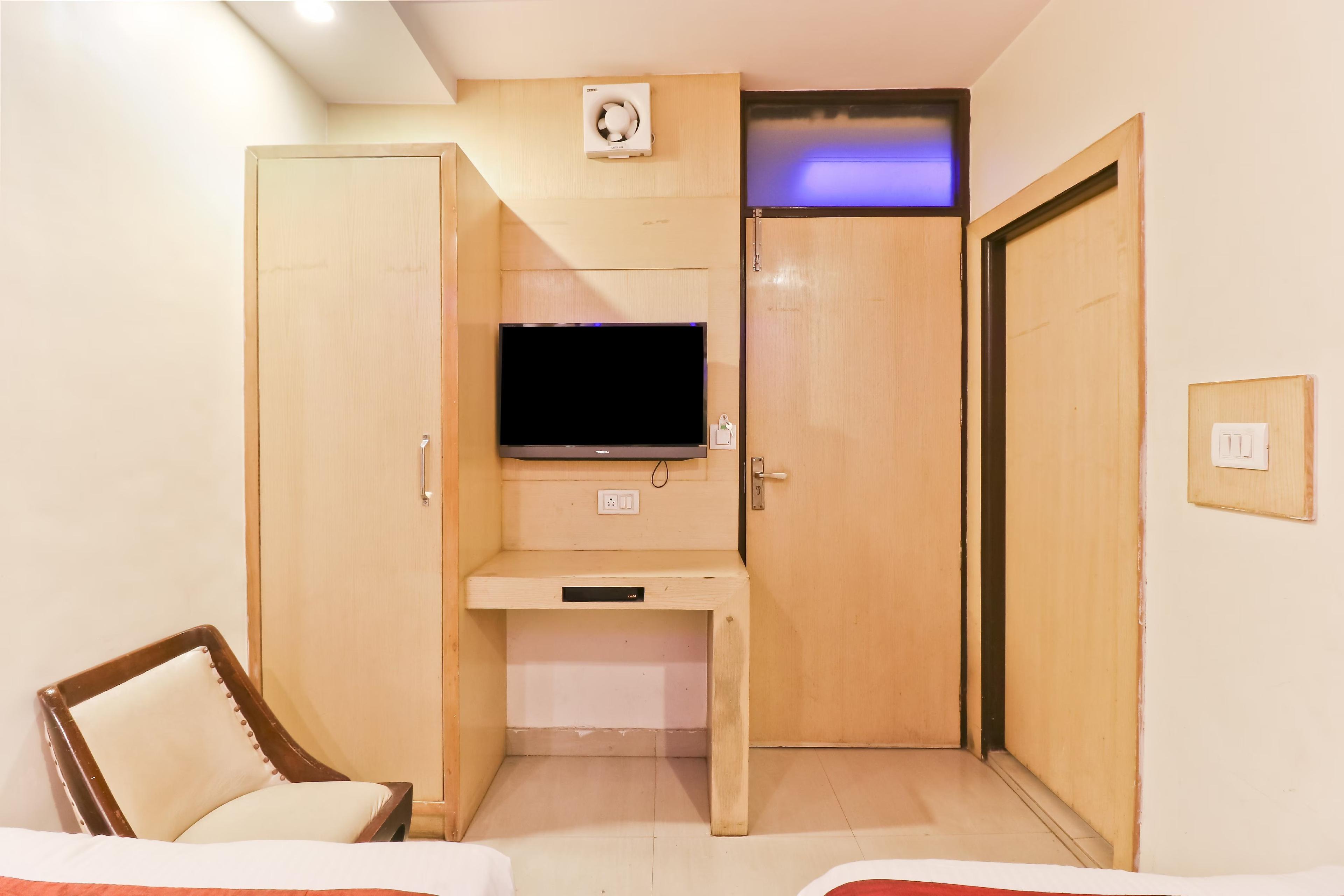 a hotel room with a tv and a chair at travok resort and spa in mussoorie hotel_Image