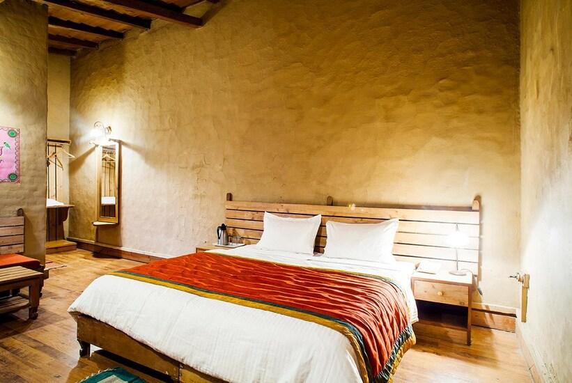 a bedroom with sofa at chevron eco lodge in kasauni hotel_Image