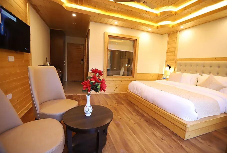 a bed room with seating area at golden wood manali in manali hotel_Image