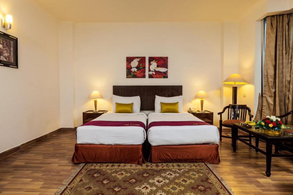 a bed room with sofa at goodwill hotel new in delhi hotel_Image