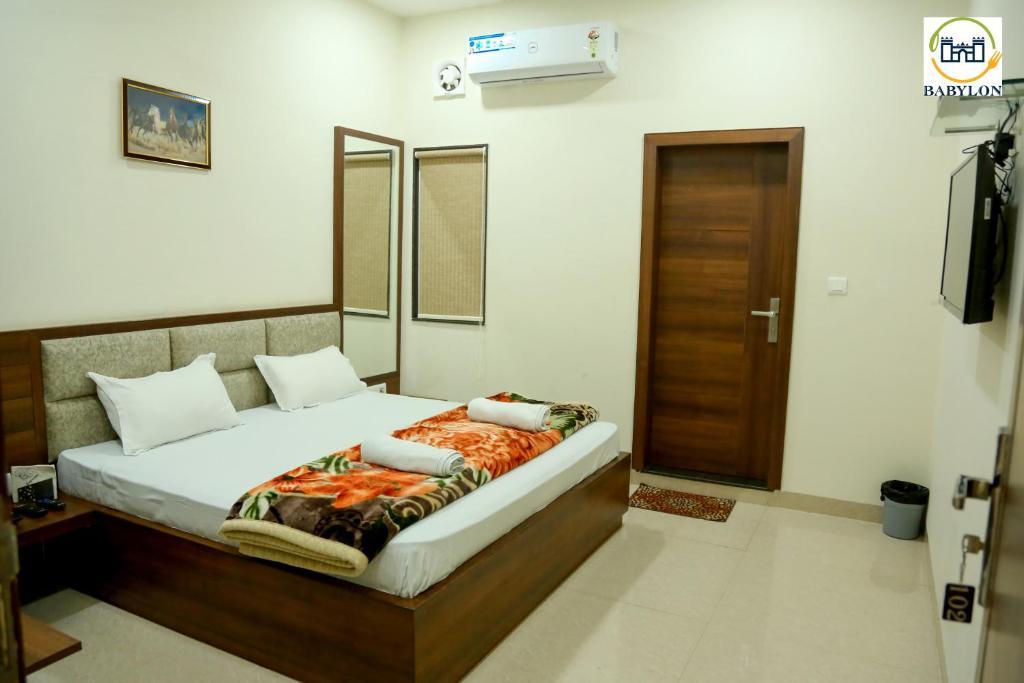 a bed room with t.v at hotel babylon regency in mathura hotel_Image