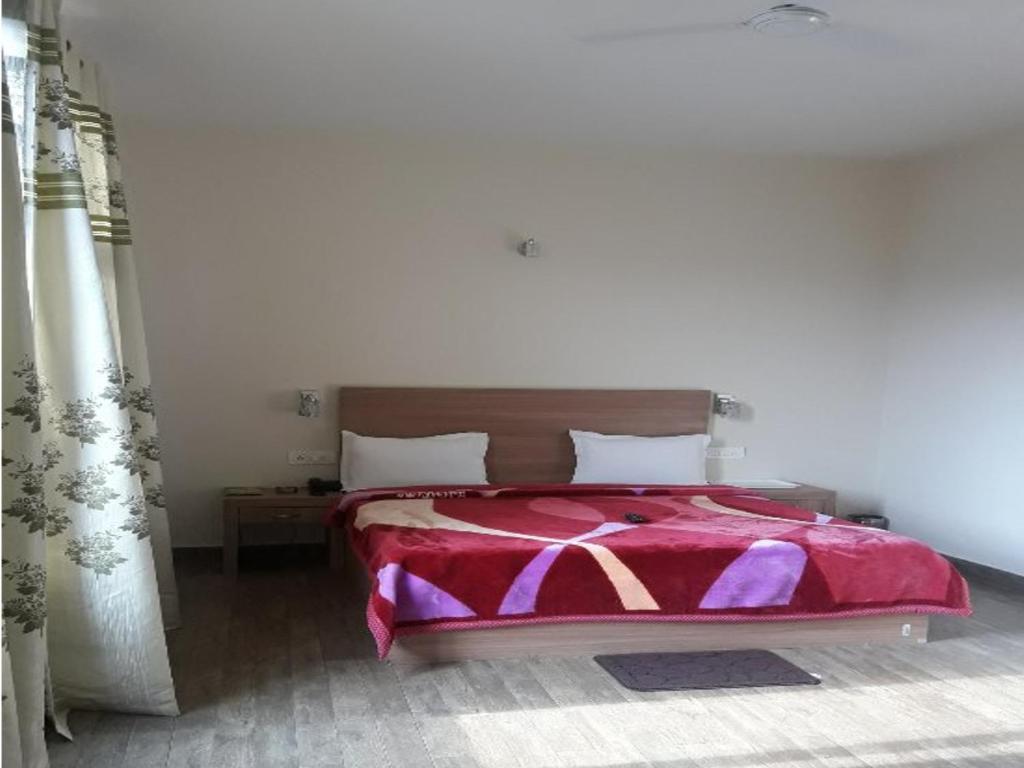 a bedroom with a large bed and a table at hotel emerald valley in Chail hotel_Image