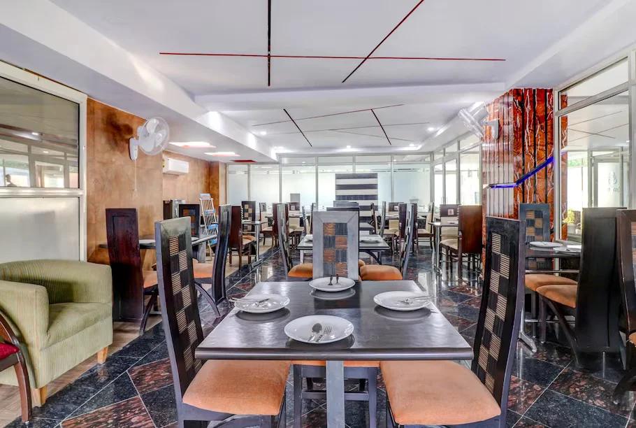 a dinner area with chairs and table at hotel green earth in Gurugram hotel_Image