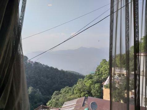 a bedroom with window view at the imperial square in mussoorie hotel_Image