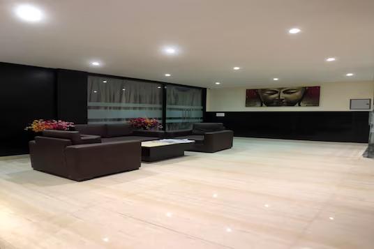 a hall area with a table and a black sofa at hotel solitaire in Chandigarh hotel_Image