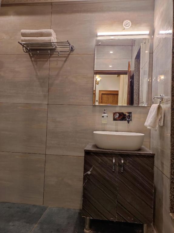 a bathroom with a sink a mirror at a mountains view from hotel roof hotel_Image