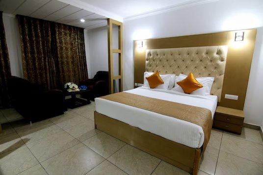 a double bed room with a sofa at hotel trinetar gardens banquets in jammu hotel_Image