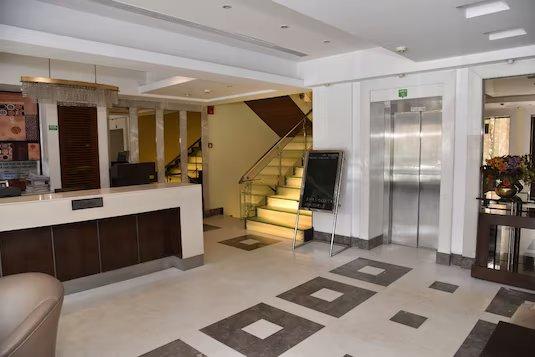 a reception area with stairs at staybook hotel western court in Chandigarh hotel_Image