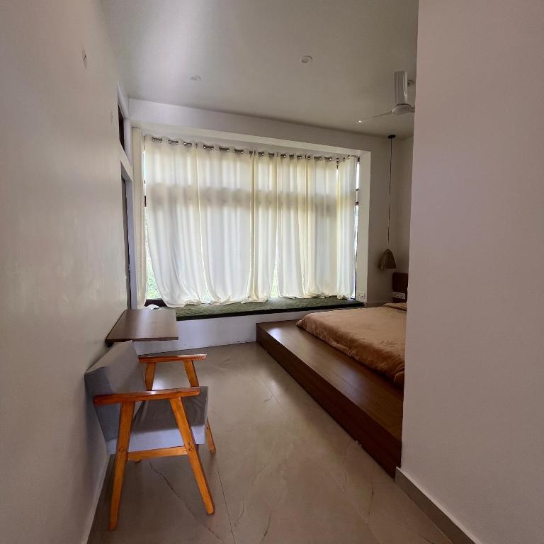 a bedroom with a chair at house of views in Bir Billing hotel_Image