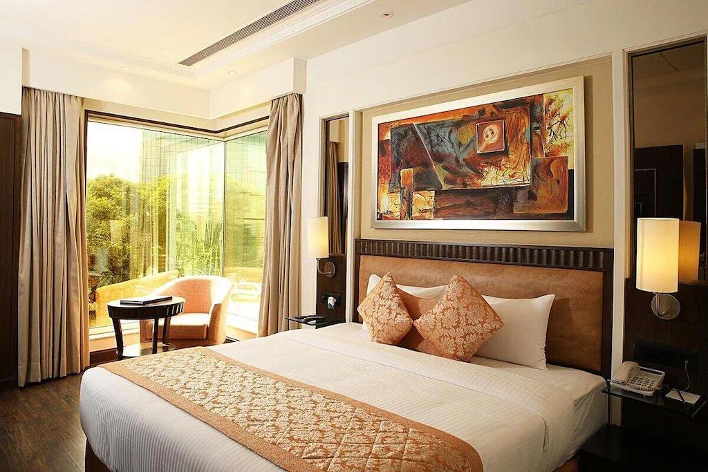 a bedroom with a large bed and a sofa at inde hotel signature tower in gurugram hotel_Image