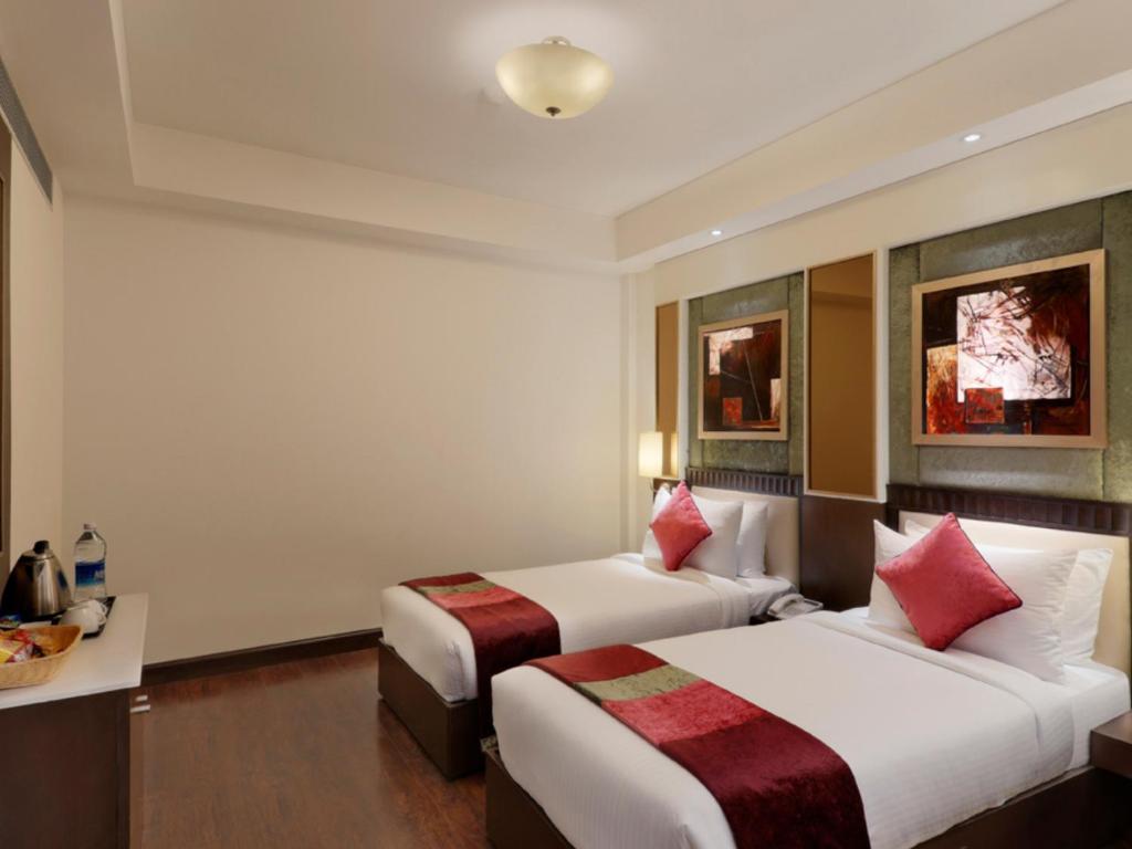 a bedroom with two single bed and a bottle at staybook Inde hotel vista woods in Gurugram hotel_Image