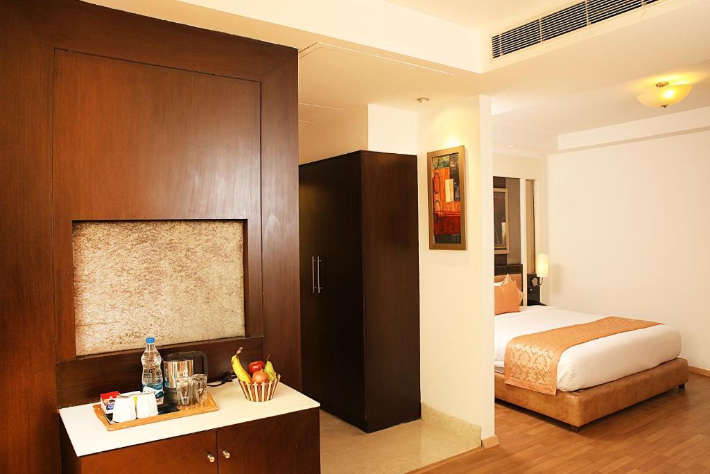 a bedroom with a single bed and a tv at staybook Inde hotel vista woods in Gurugram hotel_Image