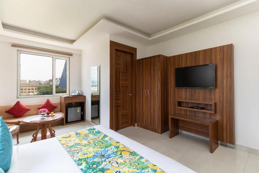 a bedroom with a large bed and a tv at staybook inde hotel cyber city in Gurugram hotel_Image