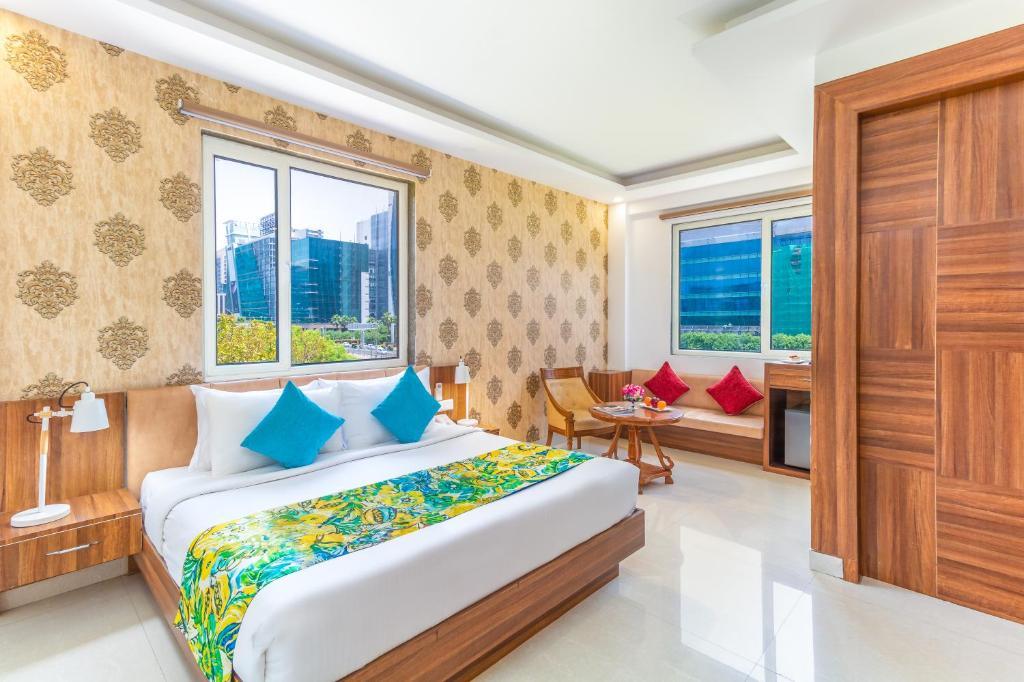 a bedroom with a large bed and sofa at staybook inde hotel cyber city in Gurugram hotel_Image