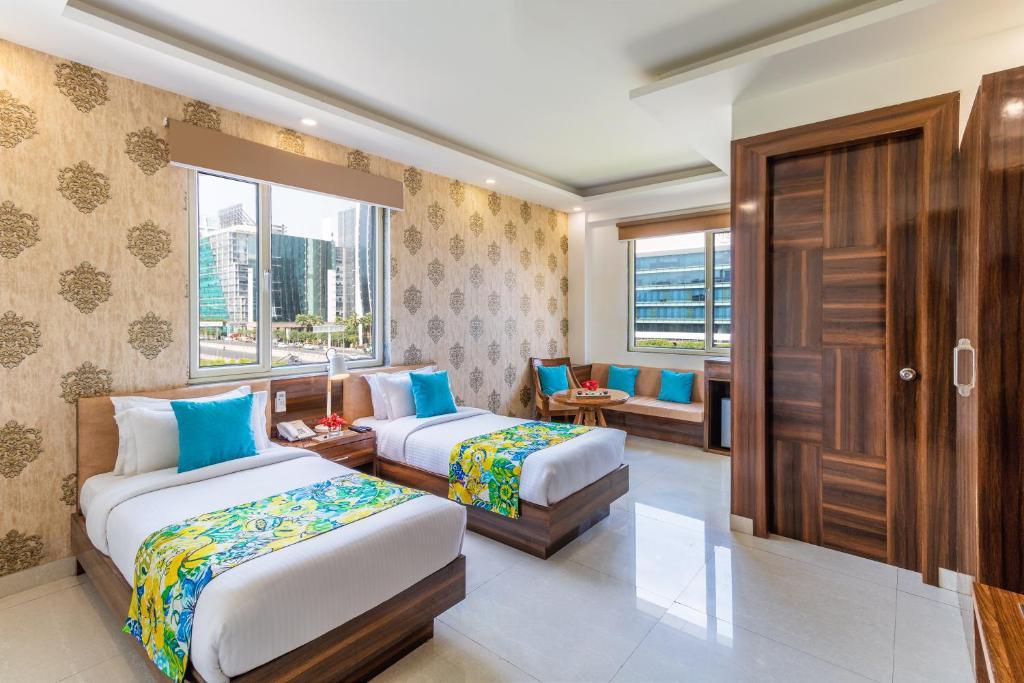 a bedroom with two single bed and sofa at staybook inde hotel cyber city in Gurugram hotel_Image