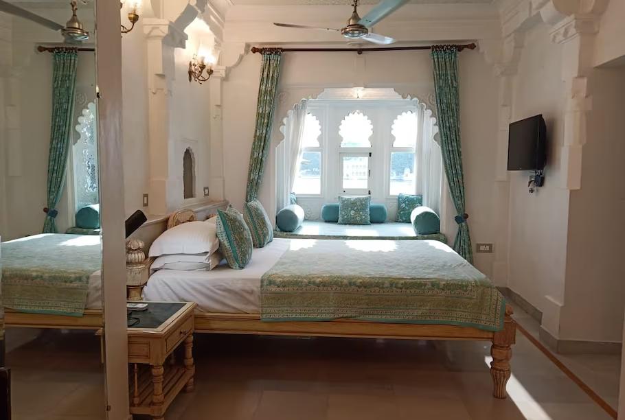 a bedroom with a large bed and sofa at staybook jagat niwas palaca hotel in udaipur hotel_Image