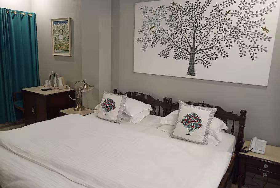 a bedroom with a large bed and a table at staybook jagat niwas palaca hotel in udaipur hotel_Image