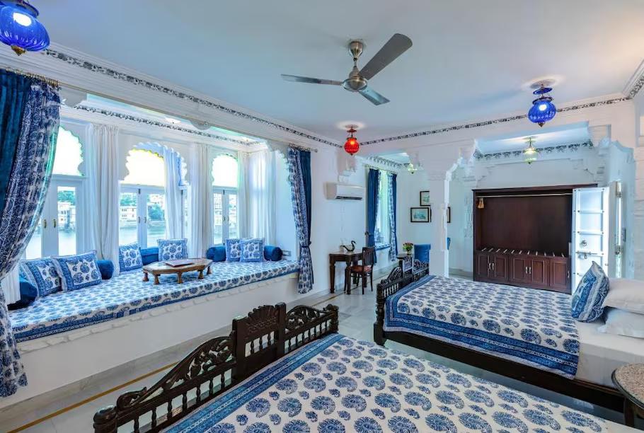 a bedroom with a large double bed and a sofa at staybook jagat niwas palaca hotel in udaipur hotel_Image
