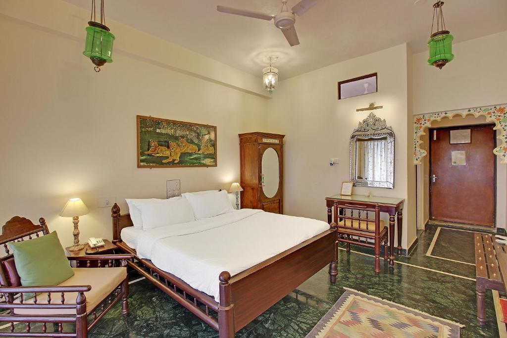 a bedroom with a large bed and a table at lake pichola hotel in udaipur hotel_Image
