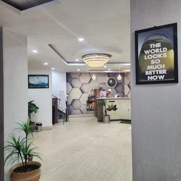 a reception desk with a stairs and a plants at mm hotel in dharmshala hotel_Image