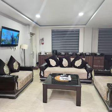 a tv and sofa at mm hotel in dharmshala hotel_Image