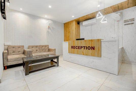 a reception desk with a sofa a table at mm hotel in chandigarh hotel_Image