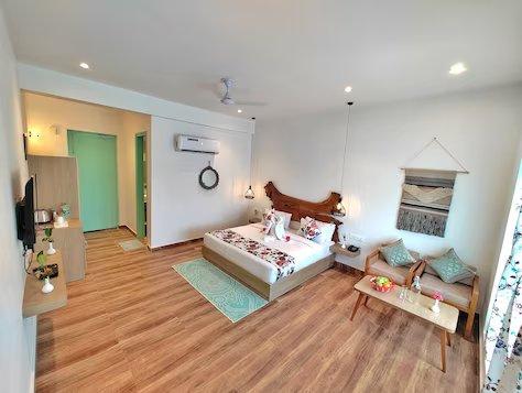 a bedroom with a sofa and a ac at mm resort and spa jim corbett in Uttarakhand hotel_Image